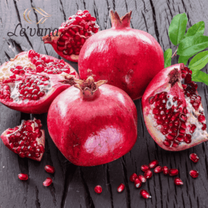 رمان طازج كامل ومفتوح بجانب أوراق خضراء – Le’vana